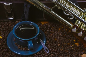 Coffee cup and coffee beans with a trumpet in the background