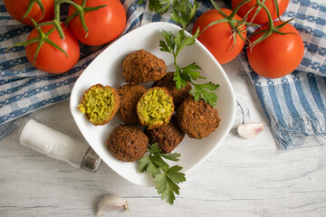 Falafel, tomatoes on a wooden background