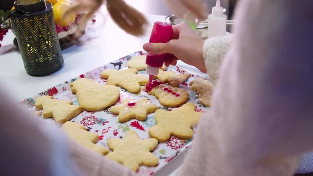 Close-up image from a kitchen how the Christmas baked goods are decorated with different fillings. On a tray with holiday pictures. Festive atmosphere