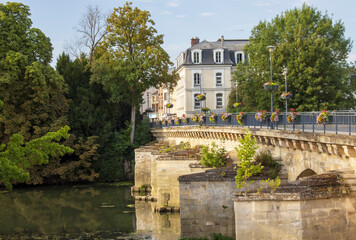 Fototapeta na wymiar Meulan-en-Yvelines, France - Saturday 30th July 2022: Stone bridge over the river seine at Meulan-en-Yvelines