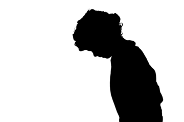 silhouette of a small boy peering down at an object.