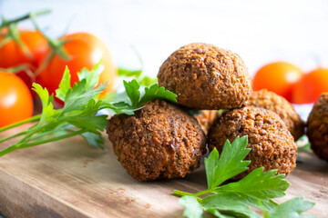 Falafel, tomatoes on a wooden background