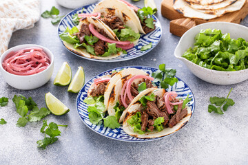 Beef tacos with lettuce and pickled red onion