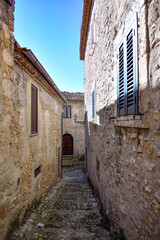 A narrow street between the old stone houses of Civitavecchia di Arpino, a medieval village in the Lazio region, Italy.