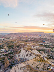 Spectacular drone view of hot air balloons flying over the underground city and fairy chimneys valley in Nevsehir, Goreme, Cappadocia Turkey. High quality photo 