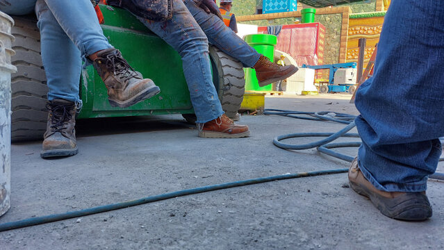 Girls wearing boots at a construction site.