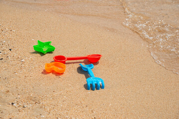 Fototapeta na wymiar Children's beach toys, Children toys on sand near sea. Beach object.