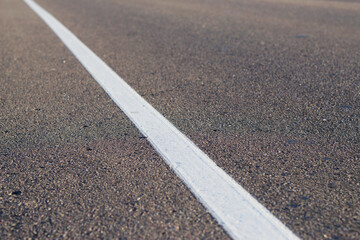 textured asphalt road with white line 