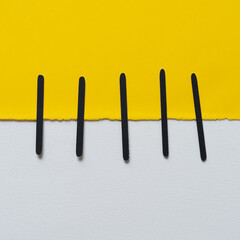square yellow note paper and black vertical lines