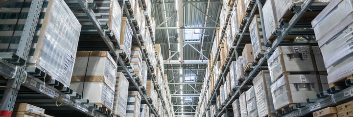 Rows of shelves with boxes in big warehouse