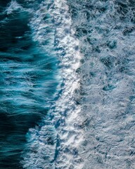 High angle long exposure shot of stunning waves splashing in the clear turquoise sea