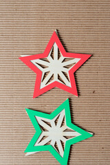 Fototapeta na wymiar wood stars with red and green star shape outlines on corrugated paper