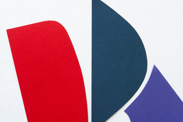 red, blue, and purple paper shapes on white