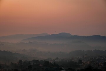 Cityscape view of Hamirpur, Himachal Pradesh with hills at sunset in a mist, India