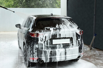 Washing auto with high pressure water jet at outdoor car wash