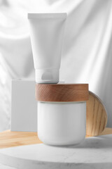 Jar and tube of hand cream on board