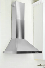 Modern range hood on white brick wall in kitchen