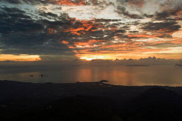 sunset over the mountains and sea at Ko Samui island taken from a drone