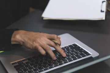 working man checking the online order on laptop with packing parcel for shipping. man working with new business about online shopping in home office and small store.
