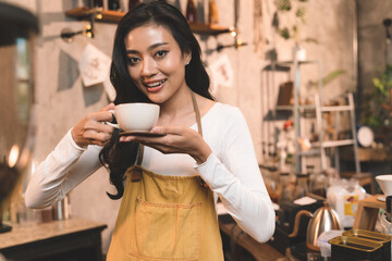 portrait of waitress handing and sip a coffee and present coffee with smiling. the happiness woman in coffee shop on waitress uniform and service customer.
