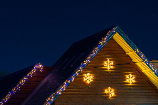 The roof of a house decorated with garlands. Night background with selective focus and copy space for text
