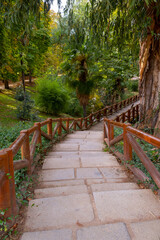 Stone Path with wooden handrail in a park in Europe during the beginning of the autunm
