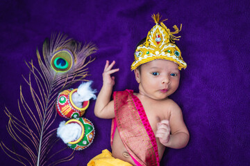 newborn baby boy in krishna dressed with props from unique perspective in different expression