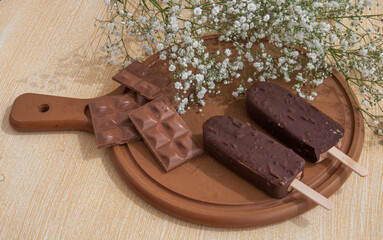 Chocolate posicle on the table with white flowers around