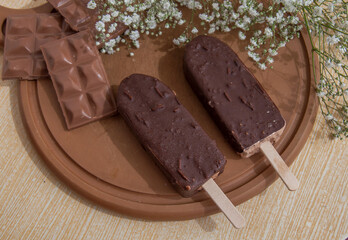 Chocolate posicle on the table with white flowers around