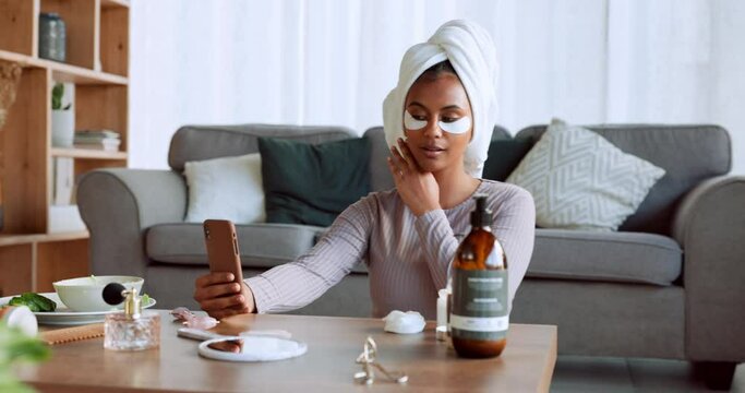 Phone, social media and beauty with a black woman influencer using antiaging under eye patch treatment in a home. Wellness, luxury and selfie with a female in her house to promote a skincare product