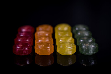 hard candies fruit flavor in various colors (red, green, yellow, orange), arranged in single color...