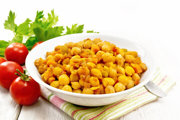 Chickpeas with vegetables stewed in plate on wooden board