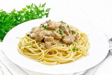 Meat in creamy sauce with spaghetti on light board