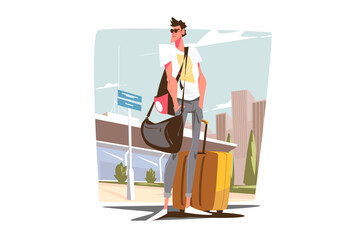 Guy tourist standing with suitcase near airport