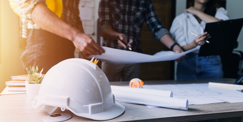 Construction engineer working at blueprint to build large commercial buildings in office....