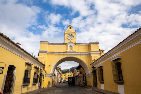 Clock Tower or Santa Catalina Arch in Antigua, Guatemala with cloudy blue sky