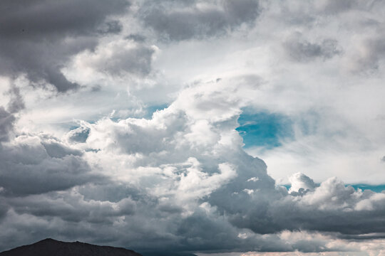 Blue sky peaks through fluffy rain clouds