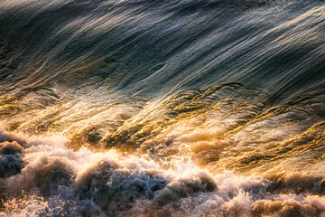Sea wave and golden sunset reflection, Pacific Ocean, California, USA, close-up. Beautiful scenery and background