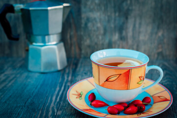 A cup of tea, rose hips and a kettle. Vitamins, disease prevention