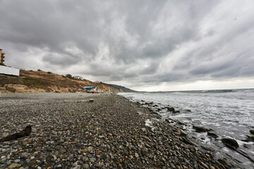 stormy weather at sea with low mountains and waves