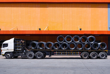 Fototapeta na wymiar Truck load with steel coil wire in front of distribution warehouse. General cargo logistics transportation and handling. Operation activities, industrial material supply chain.