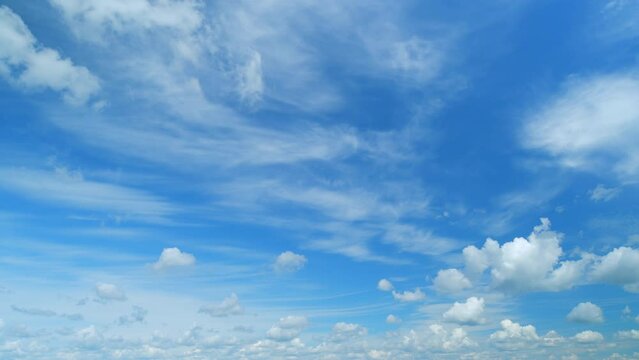 Background of clouds and sky on a sunny day. Light blue and white colours of real skies with clouds. Timelapse.