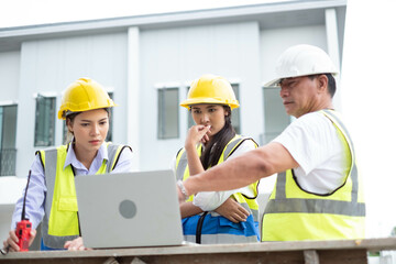 Engineers on building site. Engineer are working contruction on site plans to build high-rise buildings building. Architect caucasian man working with colleagues mixed race in the construction site.