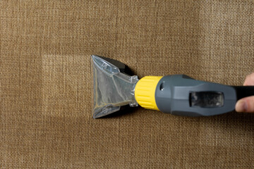 Close-up of a furniture vacuum cleaner and a dirty sofa. Cleaning and house cleaning, housekeeper...