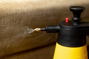 the process of cleaning furniture - a cleaning mixture flies out of the spray gun. 