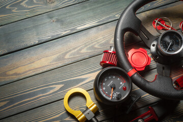 Sport car tuning accessories on the wooden workbench flat lay background with copy space.