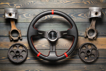 Sport car tuning accessories and car spare parts on the wooden workbench flat lay background.