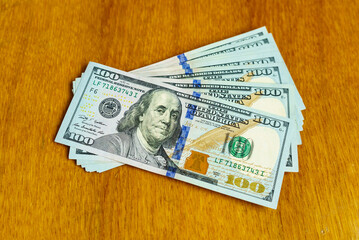 100 Dollars on a wooden table