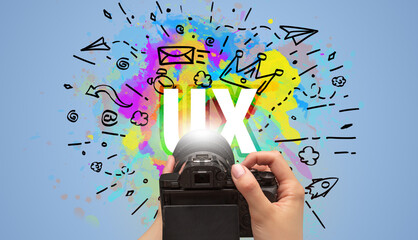Close-up of a hand holding digital camera with abstract drawing