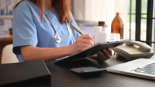 Healthcare costs and fees concept.Hand of smart doctor used a calculator and smartphone, tablet for medical costs at hospital in morning light
